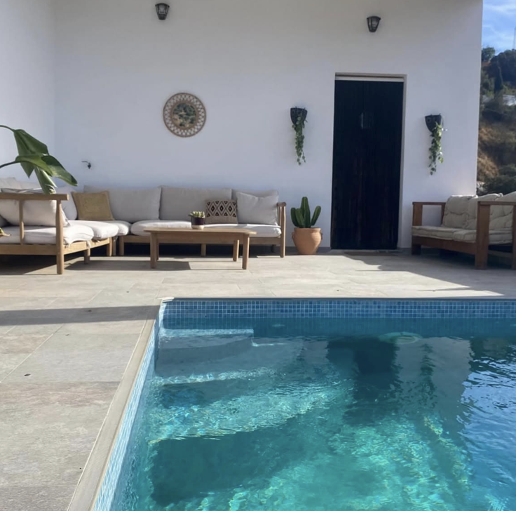 Outdoor lounge and pool at a white-walled Mediterranean villa